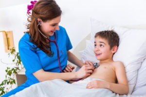 nurse holding a stethescope to a child's chest