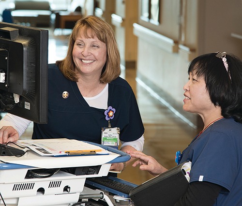 photo of nurse Kathy Mullen and a colleague discussing a case.