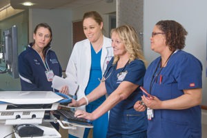 a group of doctors and nurses reviewing patient information
