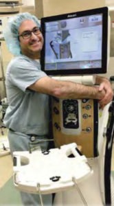 doctor in scrubs hugging surgical monitor