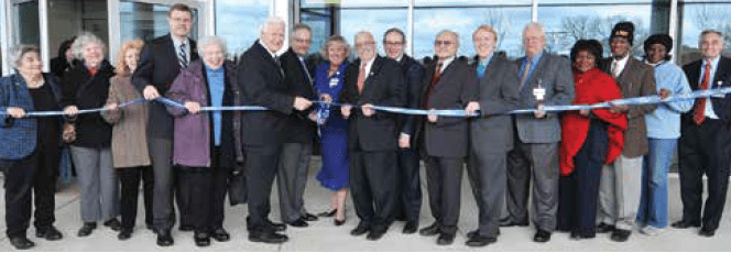a group of executives at a ribbon-cutting ceremony