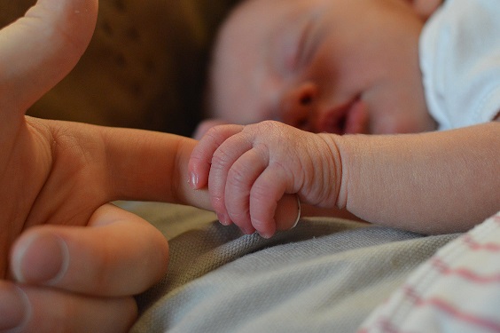 newborn grasping adult finger