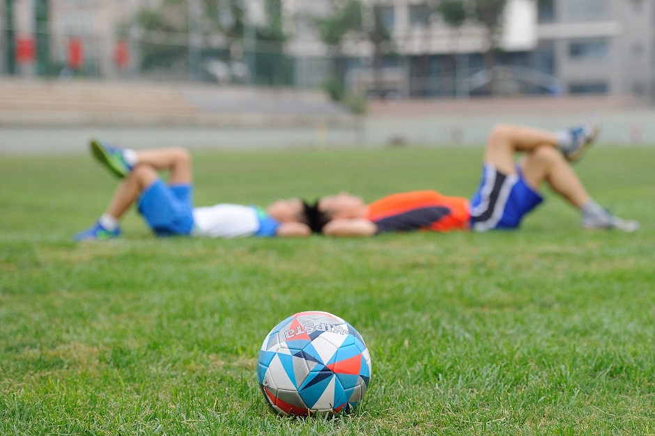 soccer ball and two players resting on the field