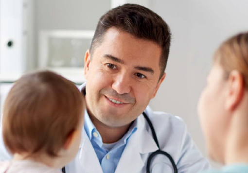 kind doctor engaging with a baby and mom