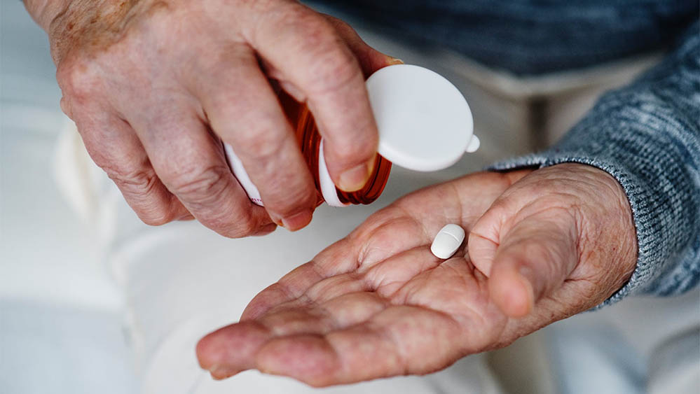 person with medication tablet on their hand
