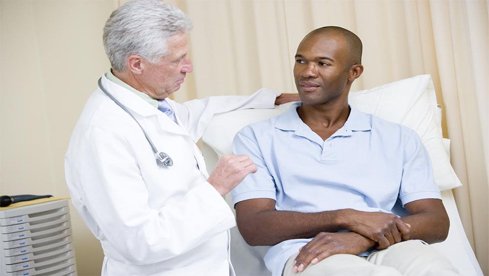 Doctor giving man checkup in exam room